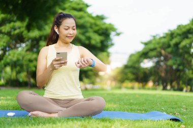 Güzel, zeki ve yakışıklı Asyalı yetişkin bir kadın güzel bir günde yoga ya da vücut ağırlığı egzersizi yapıyor ve çim tarlasında yoga yapıyor. Refah ve sağlıklı yaşam tarzı kavramı..