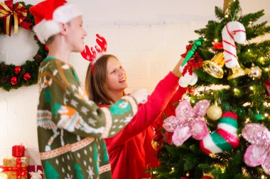 Mutlu küçük erkek ve kız kardeşler Noel ağacını bir fantezi ile süslemenin keyfini çıkarırlar. Kutlama baloları ve hediyeler, ablasının Noel ağacını süslemesine yardım eden bir çocuk..