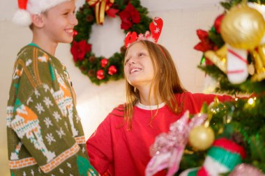 Mutlu küçük erkek ve kız kardeşler Noel ağacını bir fantezi ile süslemenin keyfini çıkarırlar. Kutlama baloları ve hediyeler, ablasının Noel ağacını süslemesine yardım eden bir çocuk..