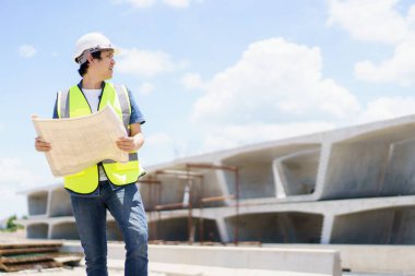 Asyalı profesyonel - köprünün planlarını ve inşaat planını inceleyen kıdemli cilt mühendisi veya inşaat mühendisi, köprü inşaatında çalışan inşaat mühendisi.