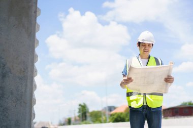 Asyalı profesyonel - köprünün planlarını ve inşaat planını inceleyen kıdemli cilt mühendisi veya inşaat mühendisi, köprü inşaatında çalışan inşaat mühendisi.