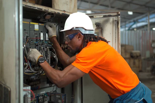 Professional electric engineer or repairman inspecting a broken electrical circuit board or fuse board in the factory, a maintenance engineer repairing a fuse box and electrical circuit.