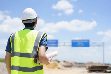 Asyalı profesyonel - köprünün planlarını ve inşaat planını inceleyen kıdemli cilt mühendisi veya inşaat mühendisi, köprü inşaatında çalışan inşaat mühendisi.