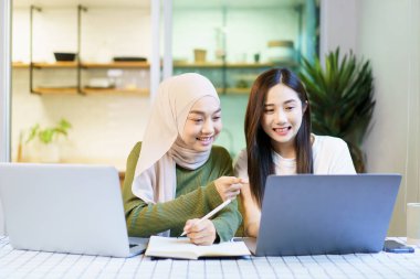 Mutlu Asyalı kadın lisansüstü öğrencisi birlikte bir proje tartışıp planlıyorlar. Çeşitli etnik kökenli insanların portresi.