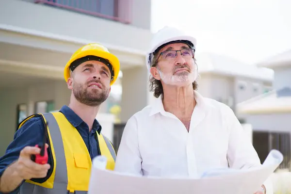 stock image Portrait of caucasian male real estate customer talking - discussing with male building foreman - engineer about construction and interior works. Construction contractor talking with client.