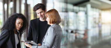 Ofis koridorunda dikilen çeşitli etnik kökenden iş adamları, iş adamı ve iş kadını ofiste konuşuyor. İş ortaklığı ve takım çalışması kavramı.