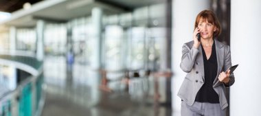 Ofis koridorunda dikilen çeşitli etnik kökenden iş adamları, iş adamı ve iş kadını ofiste konuşuyor. İş ortaklığı ve takım çalışması kavramı.