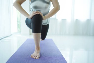 Sağlıklı Asyalı yetişkin kadın evde yoga egzersizi yapıyor. Yakışıklı Asyalı güzel kadın evde yoga egzersizi yapıyor. Ev egzersizi konsepti. Refah - sağlıklı yaşam tarzı konsepti.