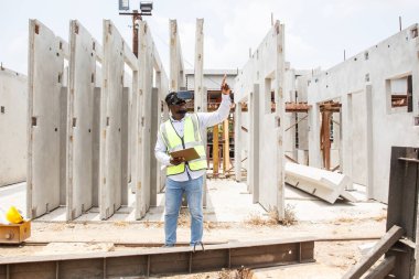 Zeki - iyi görünümlü Afrikalı siyahi etnik köken inşaat işçisi sanal gerçeklik ya da inşaat alanı incelemesinde VR gözlükleri kullanıyor.