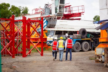 Mühendisler inşaat alanında aktif olarak çalışıyorlar, birbirleriyle detaylı tartışmalara giriyorlar. İnşaat projesinin çeşitli yönlerini işbirliği içinde inceliyorlar..