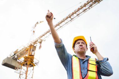 Kıdemli ustabaşı inşaat alanında ya da fabrikada teftiş yapıyor. Tehlikeli yerlerde dikkatsizce çalışıyor. Kaskı olmadan inşaat alanında çalışan dikkatsiz bir işçi..