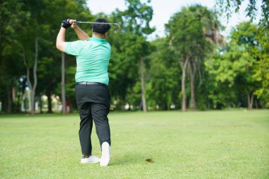 Mutlu Asyalı erkek amatör golfçü sabah golf sahasında golf oynamaktan zevk alır. Asyalı şişman adam golf oynamaya gidiyor..