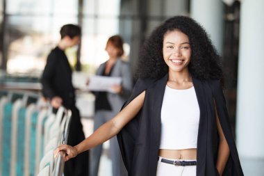 Ofis koridorunda dikilen çeşitli etnik kökenden iş adamları, iş adamı ve iş kadını ofiste konuşuyor. İş ortaklığı ve takım çalışması kavramı.