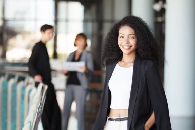 Ofis koridorunda dikilen çeşitli etnik kökenden iş adamları, iş adamı ve iş kadını ofiste konuşuyor. İş ortaklığı ve takım çalışması kavramı.