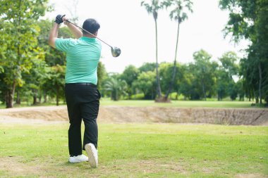 Mutlu Asyalı erkek amatör golfçü sabah golf sahasında golf oynamaktan zevk alır. Asyalı şişman adam golf oynamaya gidiyor..