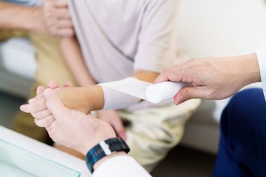 Büyükbaba, torununu bir kaza sonucu sol kolundaki yara için doktora götürdü. Doktor sakince ilaç uyguladı ve çocuğu bandajladı..