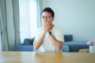 Asyalı adam evde tek başına oturuyor..