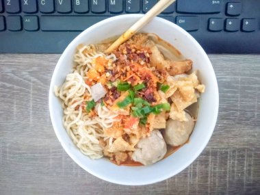 Yenilmeye hazır bir kase köfte çalışma masasında, arka planda bir klavye ile birlikte.