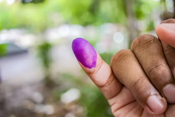 a picture of a man\'s hand. The ink on a man\'s finger was obtained after voting during the regional elections (pilkada) in Semarang, Indonesia