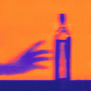 Alkol bağımlılığı konsepti - canlı neon renklerde bir şişe alkole uzanan el gölgesi 
