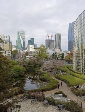 A view of Mohri Garden from Roppongi Hills in Tokyo, Japan in the spring with blooming sakura clipart