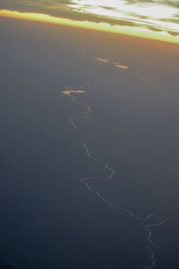Gökyüzünden gün batımı. Uçak penceresinden görüntüle