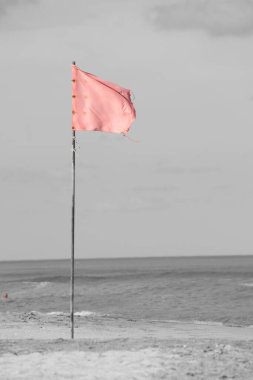 Deniz kıyısındaki kırmızı bayrak, banyo yapmanın yasak olduğunu gösteriyor.