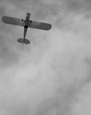 Bulutlu gökyüzünde dönen küçük bir uçak