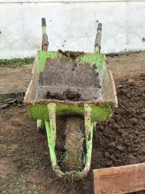 İnşaat alanında yeşil el arabası. Binalar