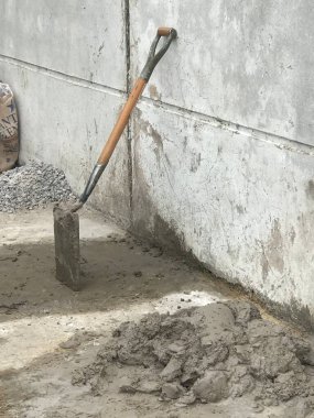 İnşaat alanının duvarına yaslanmış kürek.