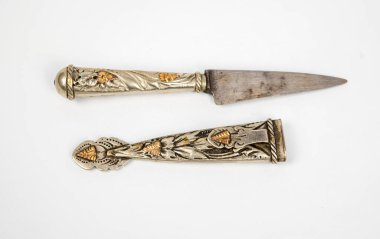 Kılıfıyla süslenmiş eski bir bıçak.