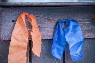 Kapıda turuncu ve mavi renkli flamalar asılı.