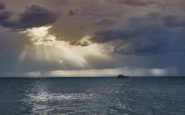Roma şeyleri denizi ve bulutların arasından geçen güneş.         