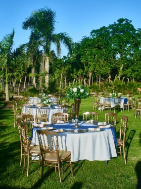 Beyaz sandalyeli ve çiçekli güzel bir düğün masası.