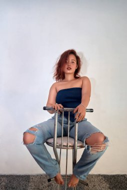 Beyaz gömlekli ve mavi pantolonlu genç bir kadın.