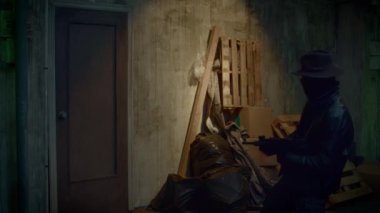 A mysterious man in black is shooting with a machine gun at a door in a backstreet.