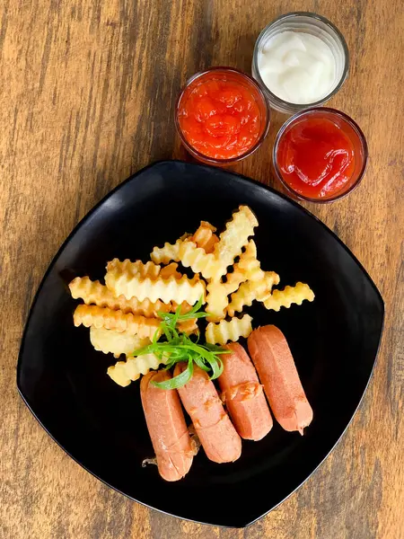 Sosis ve soslu patates kızartması.