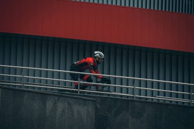 Şehirde bisiklete binen genç adam, gündüz manzaralı. 