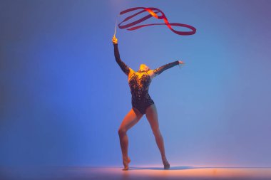 Ritmik jimnastik iş başında. Ritmik jimnastikçi kadın stüdyoda dans ediyor..