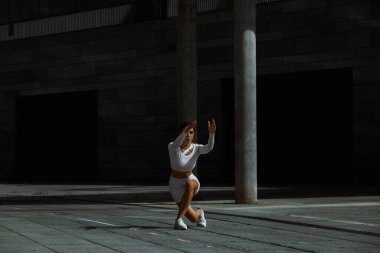 Sportif kız sokakta fonksiyonel eğitimle performans sergiliyor.