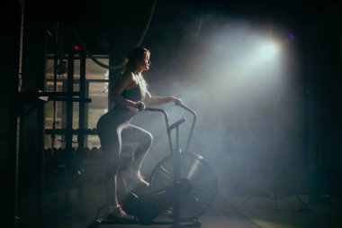 Spor salonunda kıvırcık saçlı sarışın genç bir kadın.