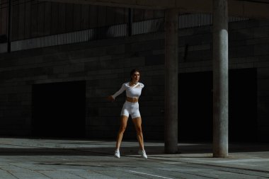 Sportif kız sokakta fonksiyonel eğitimle performans sergiliyor.