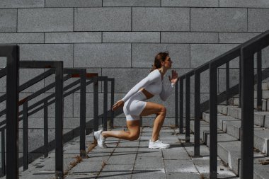 Sportif kız sokakta fonksiyonel eğitimle performans sergiliyor.