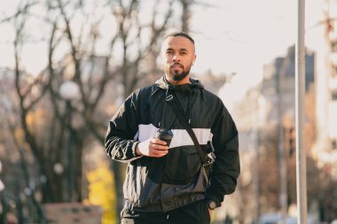 Genç adam gündüz vakti büyük şehrin ortasında yürüyor.