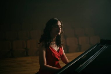 Konser salonunda piyano çalan kadın.