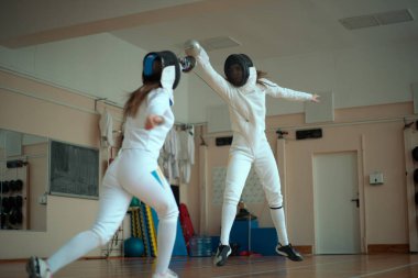 Eskrim sporu. Salonda iki kız eskrim eğitimi..