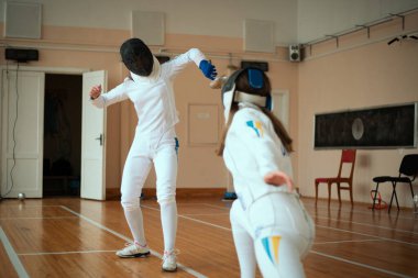 Eskrim sporu. Salonda iki kız eskrim eğitimi..
