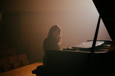 Konser salonunda piyano çalan kadın.