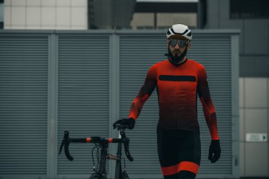 Şehirde bisiklete binen genç adam, gündüz manzaralı. 