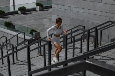 Sportif kız sokakta fonksiyonel eğitimle performans sergiliyor.